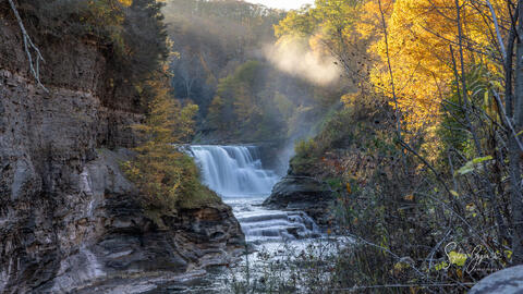 waterfall in a rock valley with sunlit mist