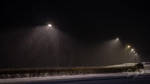 street lights at night with snow falling