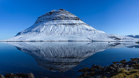 mirrored reflection of a snow-capped mountain in water