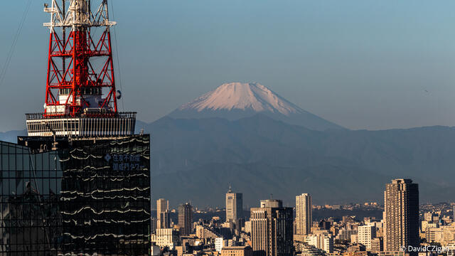 telephoto view of volcanic Mount Fuji in the distance that still dominates the horizon over city of Tokyo